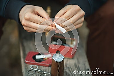 Vape. Male hands prepare cotton for an electronic cigarette. Stock Photo