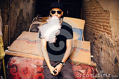 Vaper with beard in sunglasses vaping outdoor Stock Photo