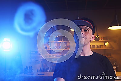 Vaping man in a cloud of vapor in a vape bar Stock Photo