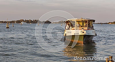 Vaporetto sails in Venice lagoon at sunset, Italy. Editorial Stock Photo