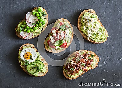 Variation avocado sandwich - with crispy bacon, quail egg, tomatoes, goat cheese, green peas, radish, cucumber. Healthy snack. Stock Photo