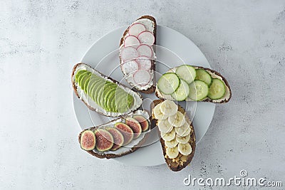 Variation of healthy breakfast sandwiches with avocado, cucumber, fig fruit, banana, cream cheese and wholegrain bread Stock Photo