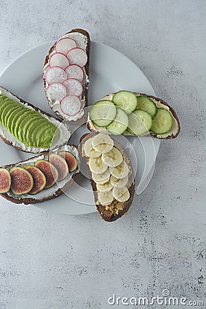 Variation of healthy breakfast sandwiches with avocado, cucumber, fig fruit, banana, cream cheese and wholegrain bread Stock Photo