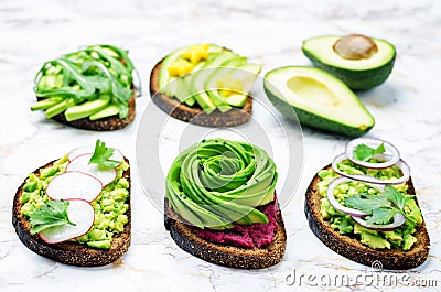 Variation of healthy rye breakfast sandwiches with avocado and toppings Stock Photo
