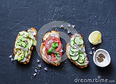 Variations of sandwiches - with cream cheese, avocado, tomato and cucumber on a dark background, top view. Healthy diet food conce Stock Photo