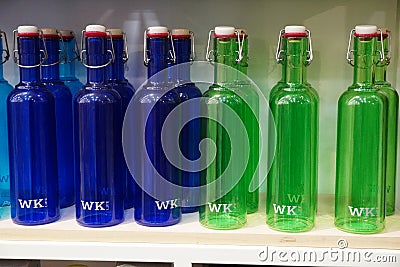 Variety of assorted colored bottles stacked in a row on shelf for sale. Decoration concept. Antique bottle are for sale in super Editorial Stock Photo