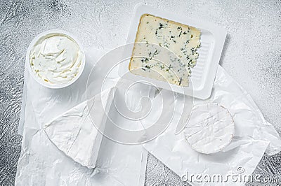 Variety of cheese kinds on kitchen table, brie, Camembert, Gorgonzola and blue creamy cheese. White background. Top view Stock Photo