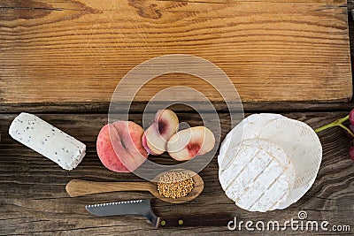 Variety of cheese with peach, spoon, knife and chopping board Stock Photo