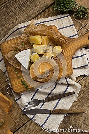 A variety of cheeses on a wooden board. Stock Photo