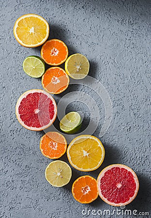 Variety of citrus fruits on a grey background, top view. Oranges, grapefruit, tangerine, lime, lemon - organic fruits, vegetarian Stock Photo