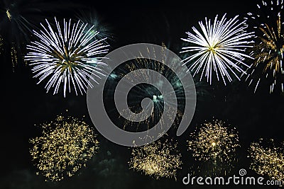 Variety colorful firework on the night sky background. Salute with yellow and blue flashes. Stock Photo