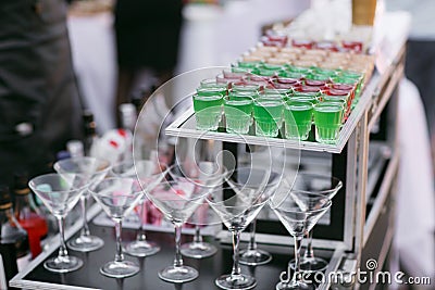 Variety of colorful green red and white beautiful alcohol sweet shooters shots cocktail fresh beverage in small glasses Stock Photo