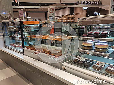 A variety of decorative cakes are placed on a glass chiller rack to make it easier for customers to choose. Editorial Stock Photo