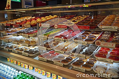 Variety of delicious donut in showcase on display at bakery cake shop Krispy Kreme. Various donuts type on shelf in Bakery shop. Editorial Stock Photo