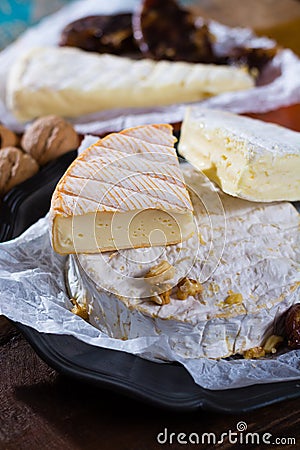 French soft cheeses - camembert, marcaire, munster, brie - delicious dessert with nuts and dried fruits Stock Photo