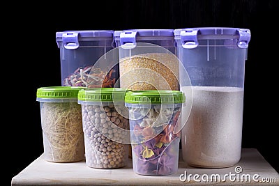 Variety of groats and pasta in plastic jars on the wooden shelf Stock Photo