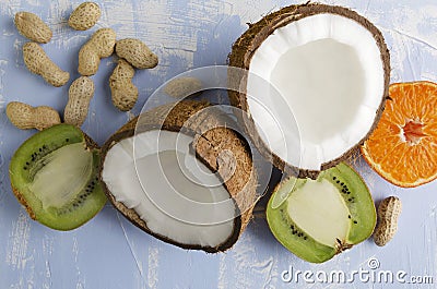 Fresh healthy veg food.Coconut,peanuts,kiwi fruit,orange on blue background Stock Photo