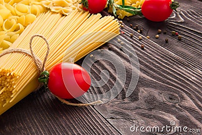 Variety of kinds and forms of dry macaroni with tomatoes and rosemary. Italian macaroni raw food or texture: pasta Stock Photo