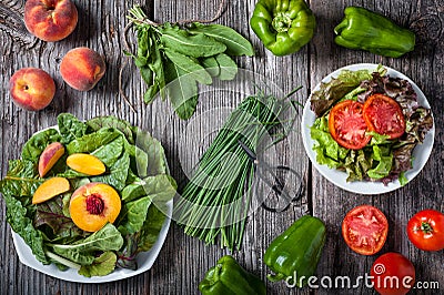 A variety of leafy greens with sliced peaches and tomatoes Stock Photo