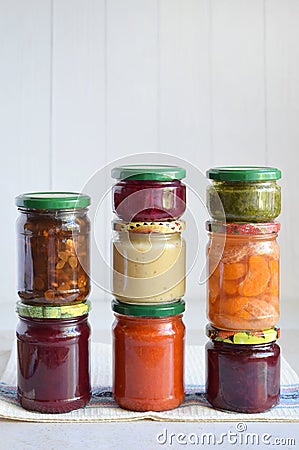 Variety of preserved food in glass jars - pickles, jam, marmalade, sauces, ketchup. Preserving vegetables and fruits. Fermented fo Stock Photo