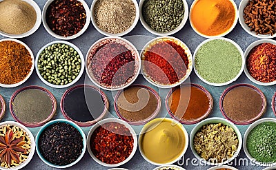 Variety of spices and herbs in bowls over grey background, top view. Generated AI Stock Photo