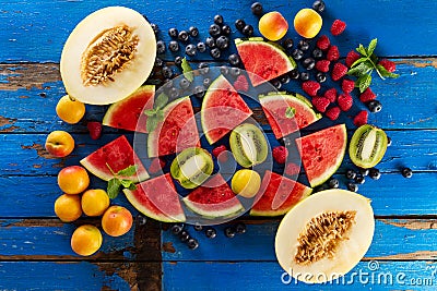 Variety of tasty fresh healthy appetizing fruits on blue wooden Stock Photo