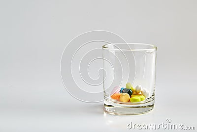 Various color pills in glass Stock Photo