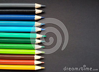 Various colored pencils over black background. Stock Photo