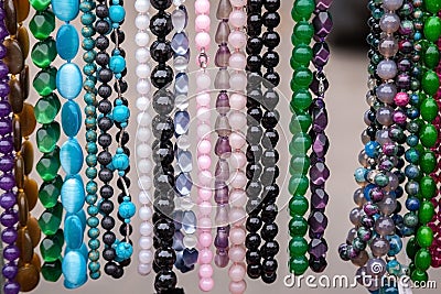 Various colorful beads in the market. Wallpaper background of a colorful necklace made of precious stones and colored beads Stock Photo