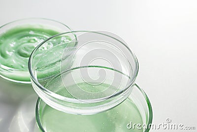 Various cosmetic products in glass petri dishes on white background with selective focus Stock Photo