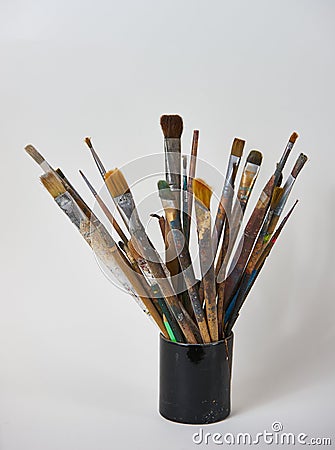 Various dirty paint brushes in a black cup isolated on white Stock Photo
