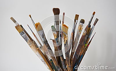 Various dirty paint brushes in a black cup isolated on white Stock Photo