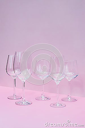 Various empty wine glasses on a pink background with space for text. Stock Photo
