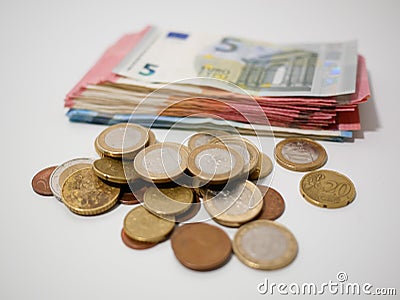 Various Euro coins and banknotes on a white desk. Notes and coins of various denominations. Stock Photo