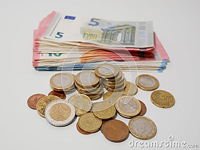 Various Euro coins and banknotes on a white desk. Notes and coins of various denominations. Stock Photo