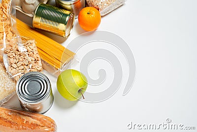 Various foods sealed in plastic bags, cans and fruits on white background, top view. Stock Photo