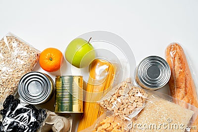 Various foods sealed in plastic bags, cans and fruits on white background, top view. Stock Photo