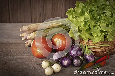 Various fresh, young homegrown vegetables, tomato, lemon grass, chilli, lettuce, Eggplant place on a wooden table Stock Photo