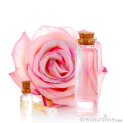 Various glass bottles with transparent liquid and pink rose Stock Photo