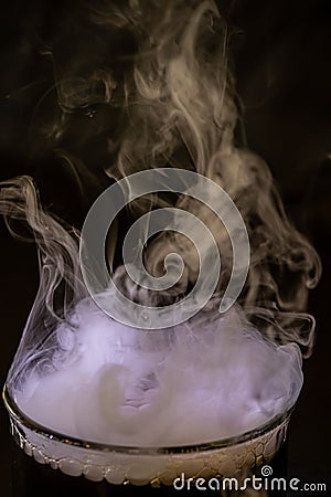 Various glasses and dishes with water and dry ice Stock Photo