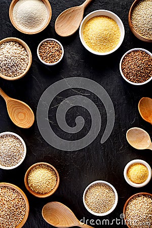 Various groats, cereals. Different types of groats in bowls on a black background, top view. Stock Photo