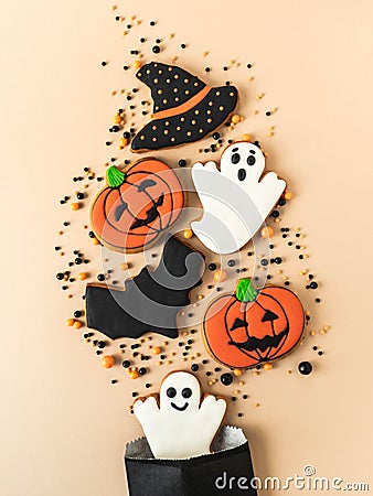 Various Halloween gingerbread cookies - Jack O`Lanterns, black hat, ghosts, bat and sugar sprinkles scattering of paper bag Stock Photo