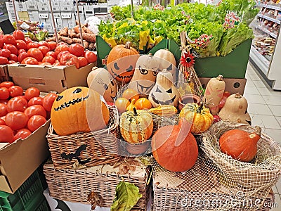 Various Halloween pumpkins lie on wicker boxes as decoration in a shopping Editorial Stock Photo