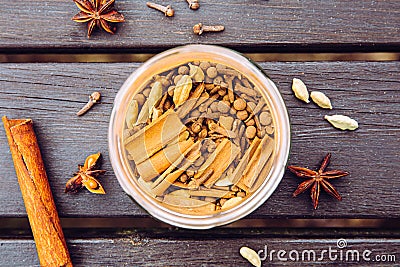 Various homemade chai tea ground ingredients in glass jar, flat lay view. Stock Photo
