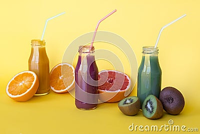 Various kind of smoothies or juices in bottles, healthy diet food concept on yellow background. Stock Photo
