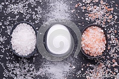 Various kinds of salt in bowls on black stone background Stock Photo