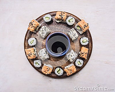 Various kinds of sushi, laid out on a wooden round tray, lined with a circle around the soy sauce Asian food on wooden rustic bac Stock Photo