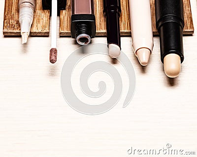Various makeup concealers on wood table. Make-up correctors. Close-up, copy space Stock Photo