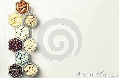 Various medical capsules and tablets in hexagonal jars Stock Photo