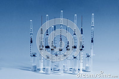 Various medical syringes and glass vials of vaccine were lined up. The concept of mass vaccination against influenza and Stock Photo
